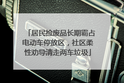 居民捡废品长期霸占电动车停放区，社区柔性劝导清走两车垃圾